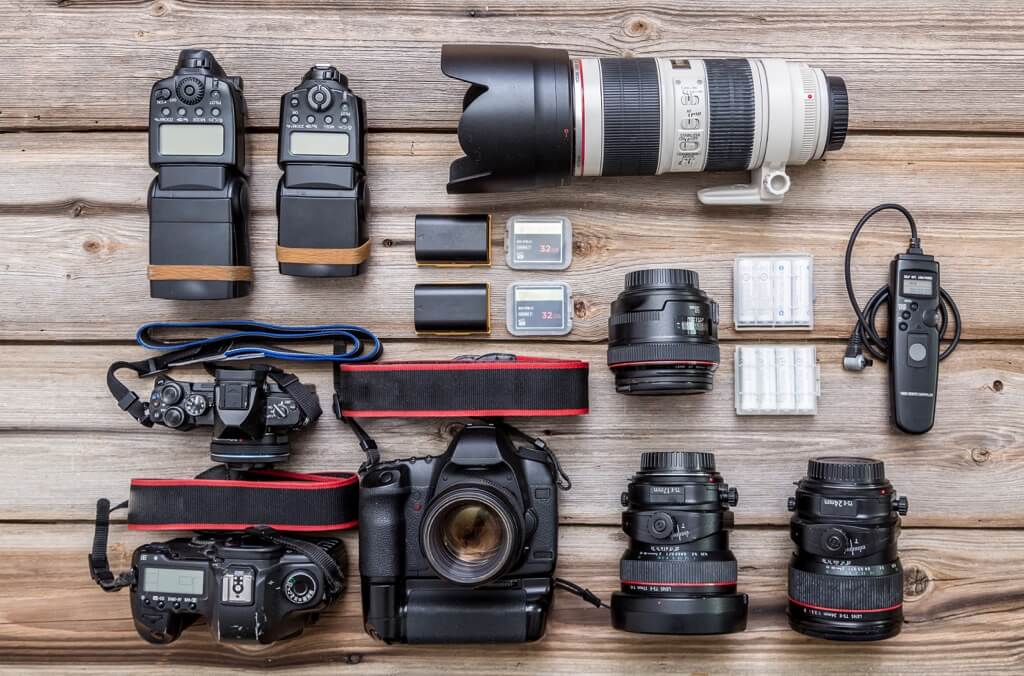 Professional camera equipment laid out including camera body, various lenses, and accessories