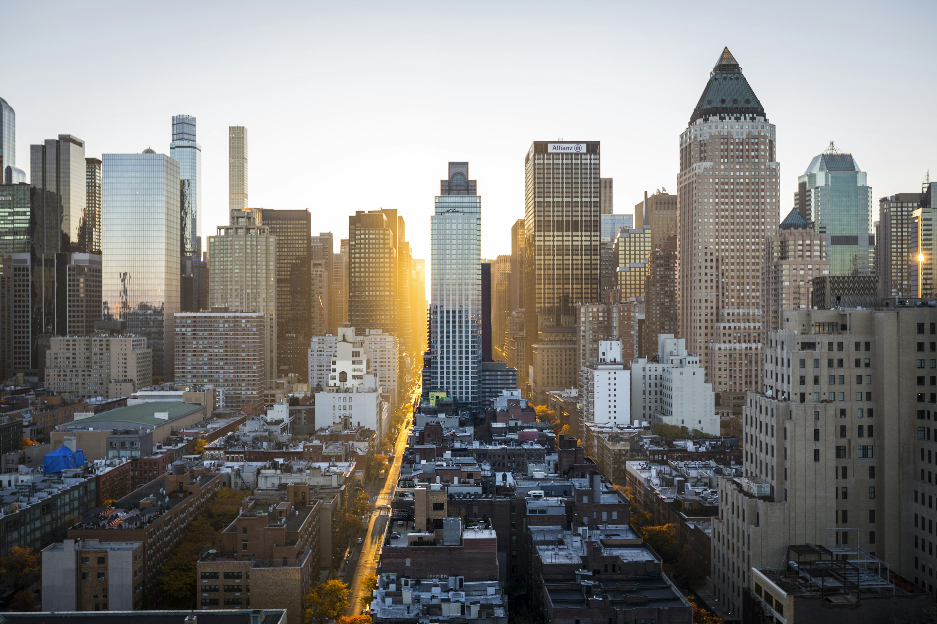 Downtown city skyline at sunset with golden light reflecting off glass buildings